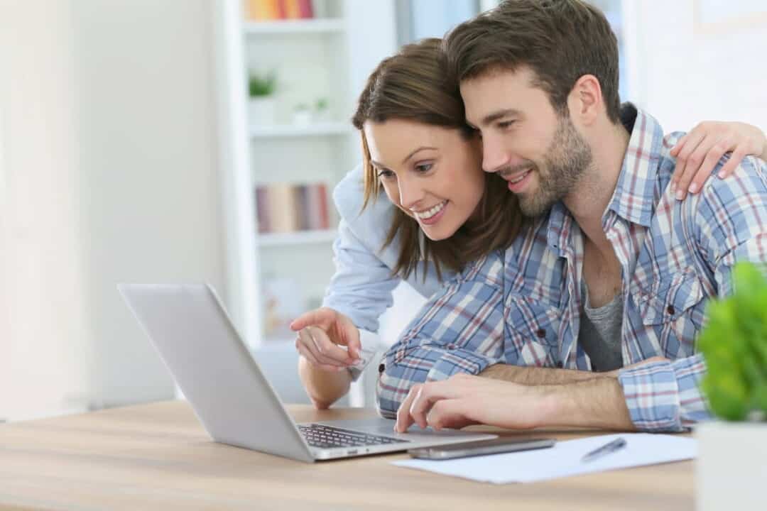 A couple calculating in front of the laptop