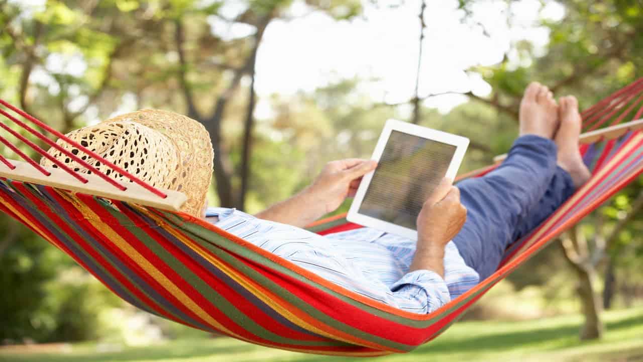 A person in a hammock holding a notebook