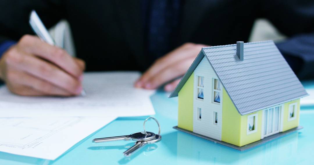 keys and house model on the table