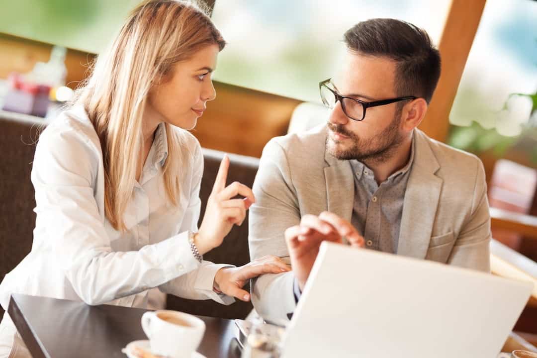 a couple sitting in front of the laptop discussing finances