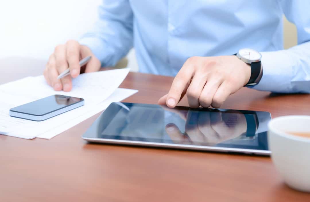 a man typing on tablet at his desk