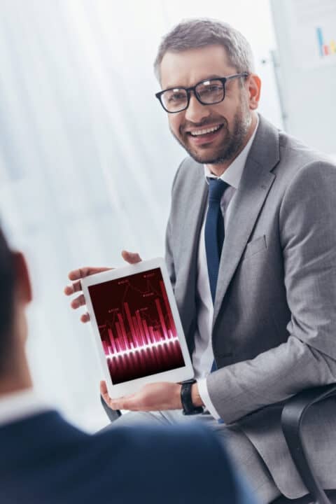 a man holding tablet with graph on the display