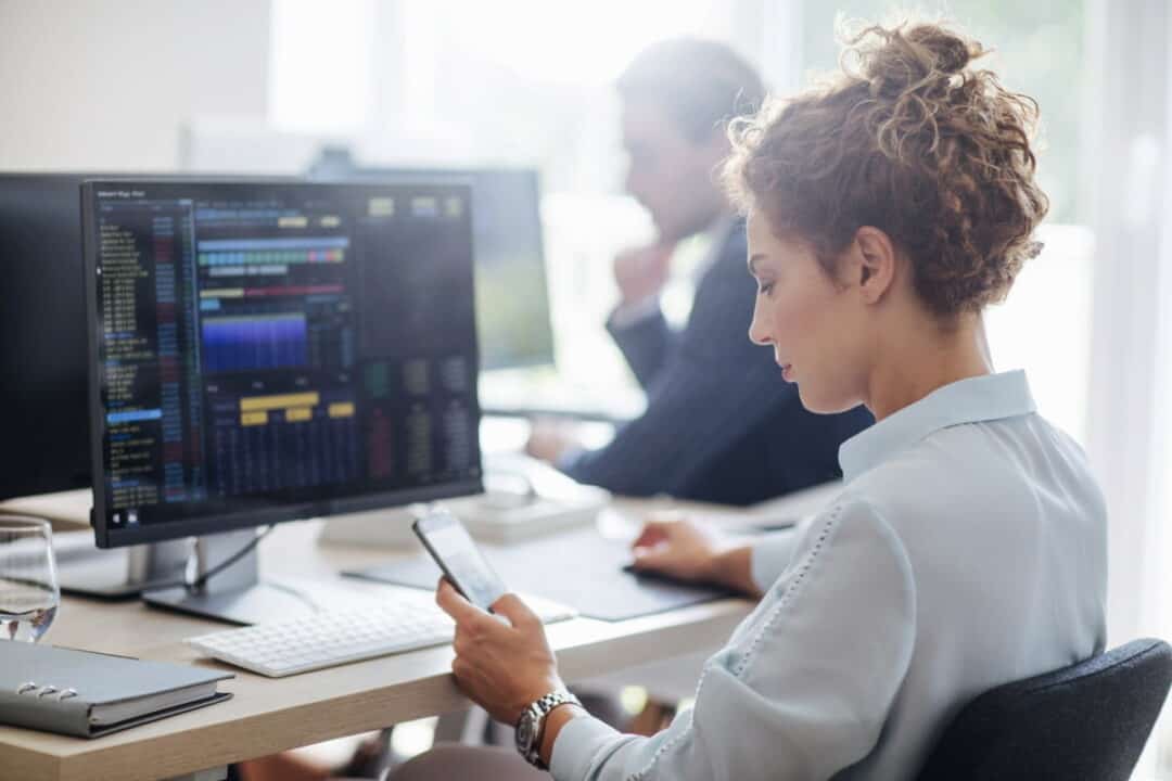 a young woman sitting in front of the monitor in the office