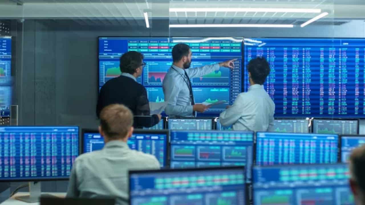 brokers watching the charts on a big display