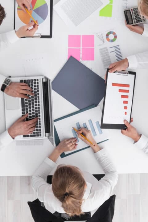 a group of people at the table analyzing graphs 