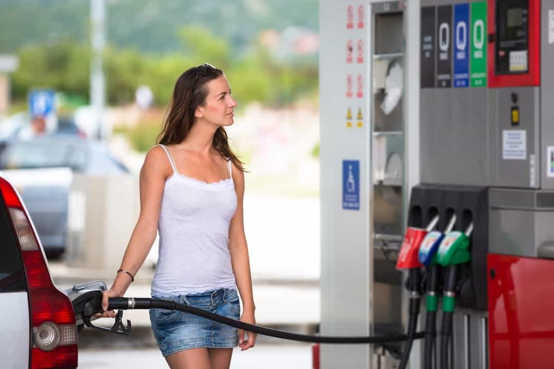 Woman refueling her car in a gas station