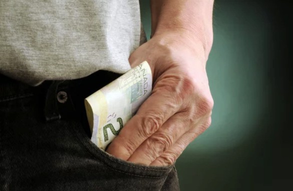 a person putting money into the pocket