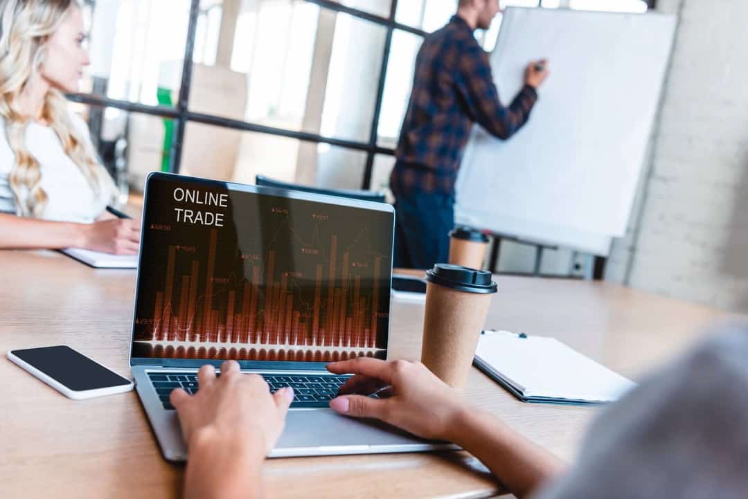 a person using laptop for online trading in an office