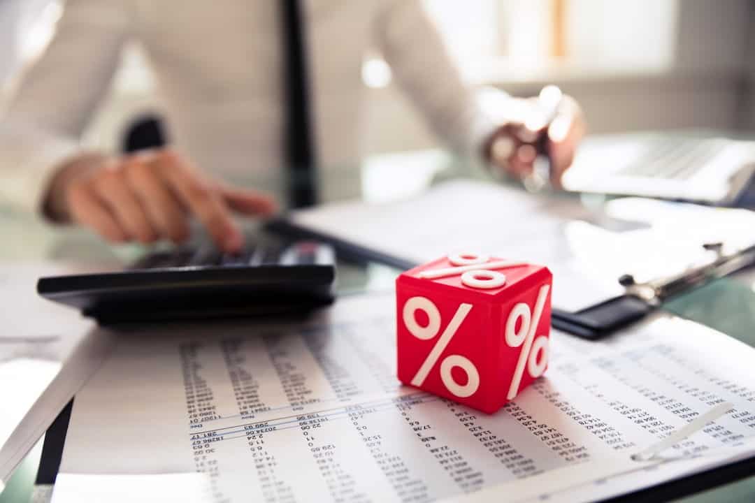 Close-up Of Red Cubic Block With Percentage Symbol on The Working Desk