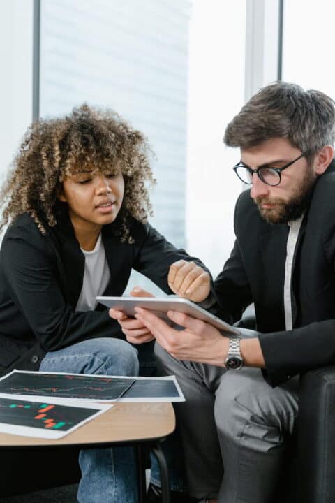 a woman and a man watching at the tablet 