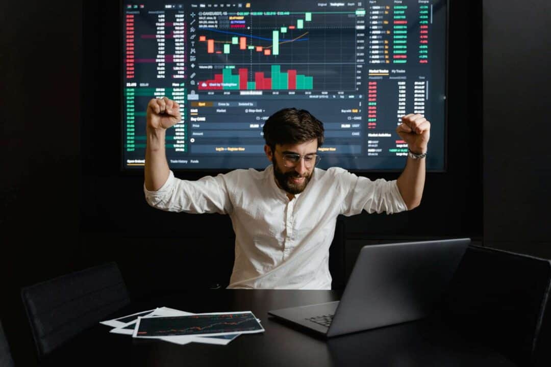 a man watching the stocks data and celebrating success