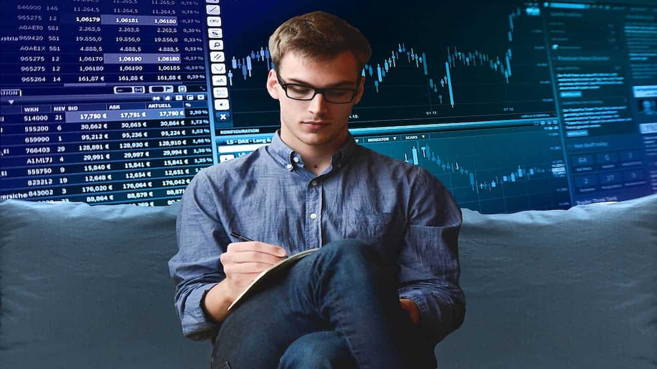 young man taking notes with a stock graph in the background